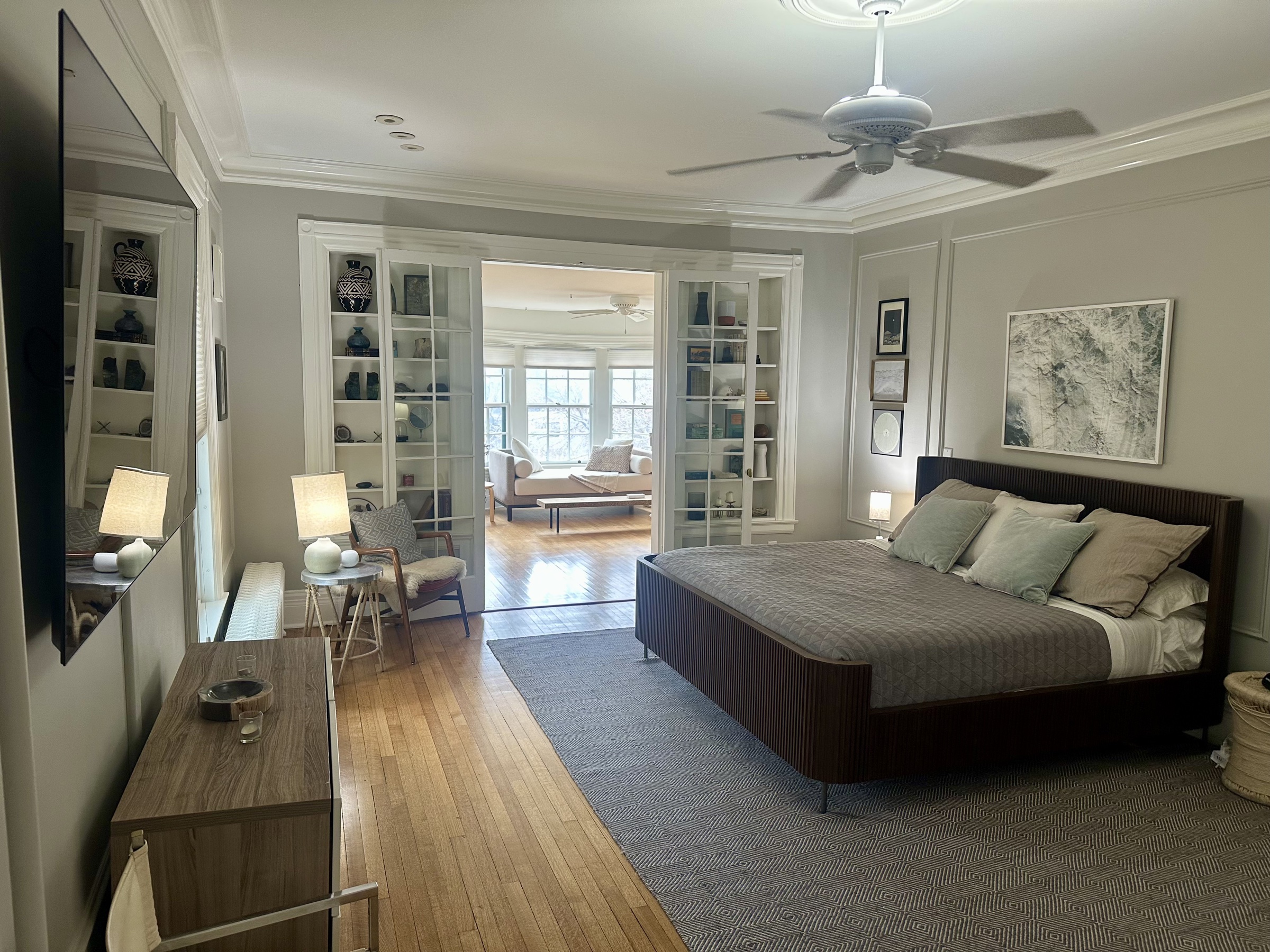 Primary bedroom opening into a sitting room with original Victorian woodwork.