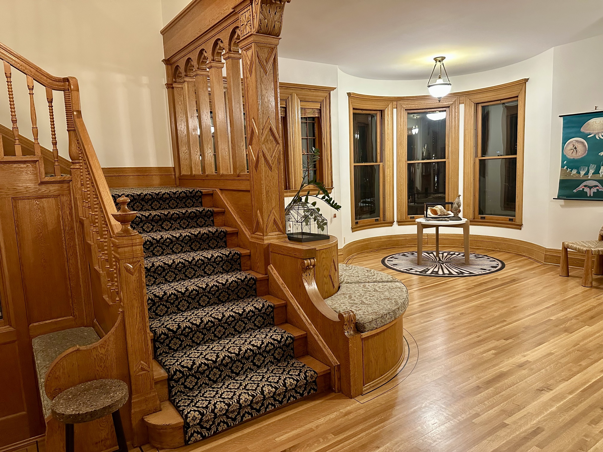 View into the wood-paneled library through a porthole door.