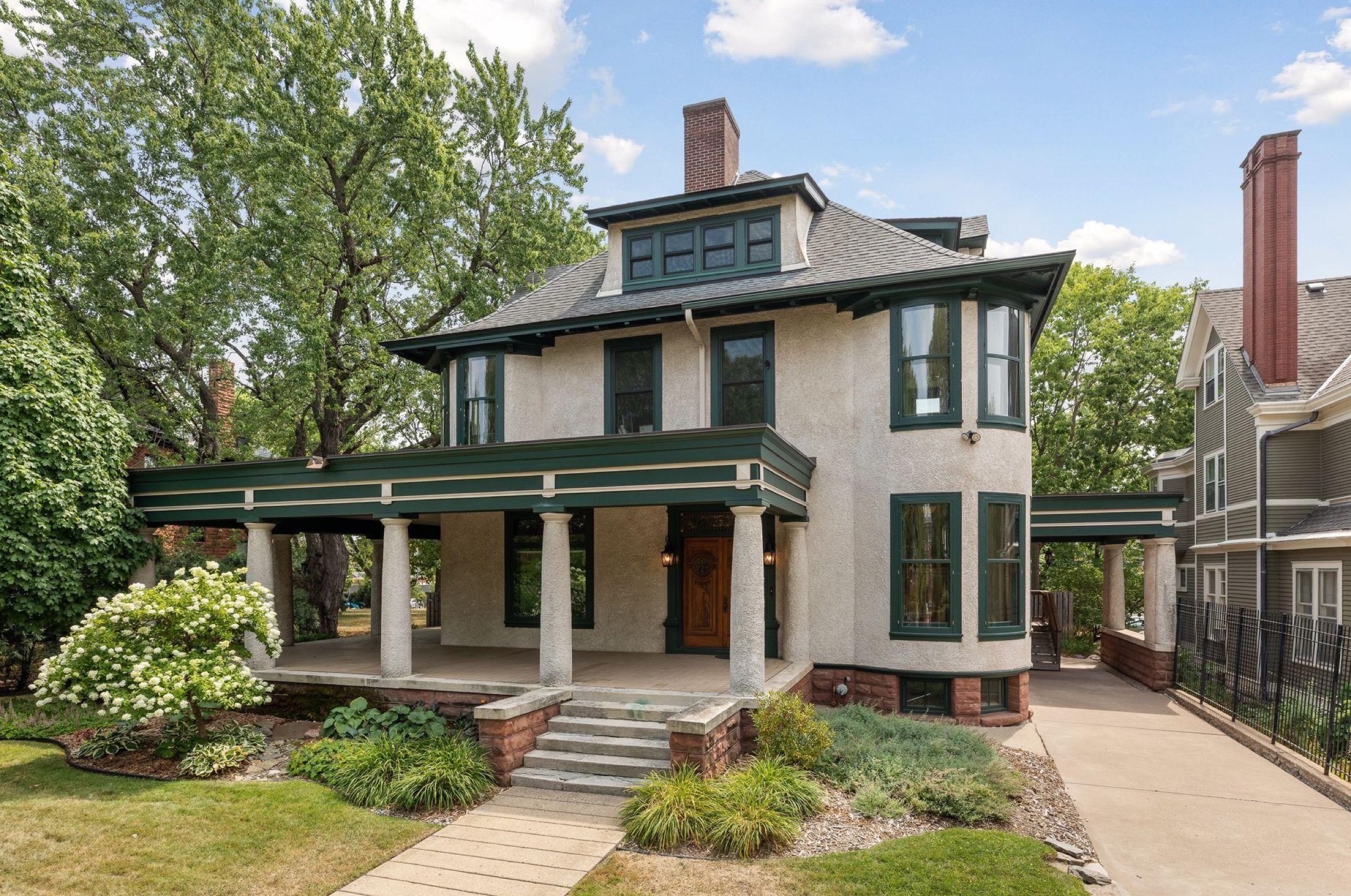 638 Summit Avenue, a Victorian mansion on Saint Paul's most storied street, framed by summer foliage.